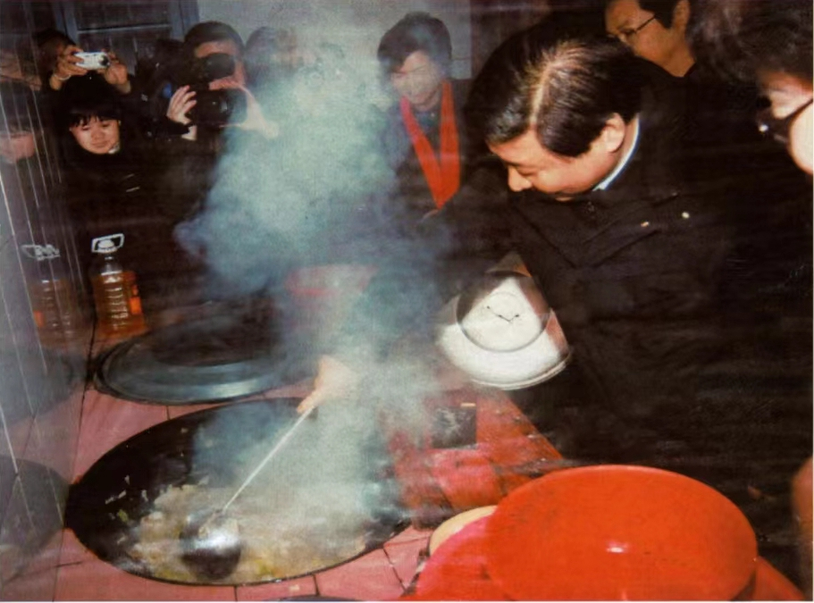 这是2007年1月,时任浙江省委书记的习近平(右一)在浙江省庆元县屏都镇敬老院为老人们炒菜。 新华社发.png